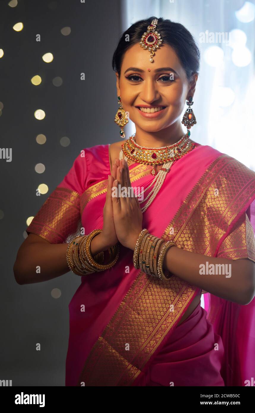 Lady in a beautiful saree greeting with her hands joined Stock Photo