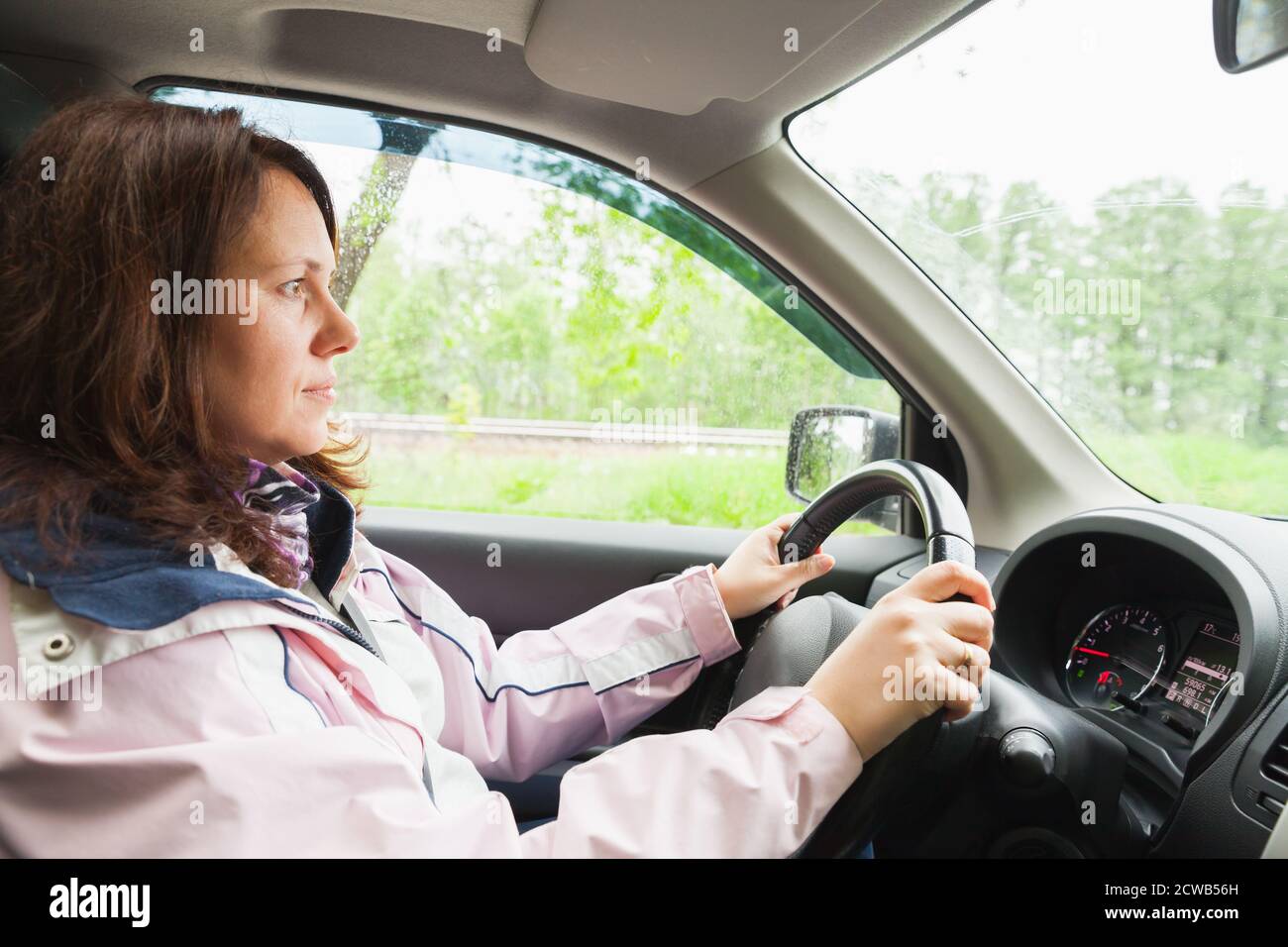 Young Caucasian woman drives a car at summer day Stock Photo