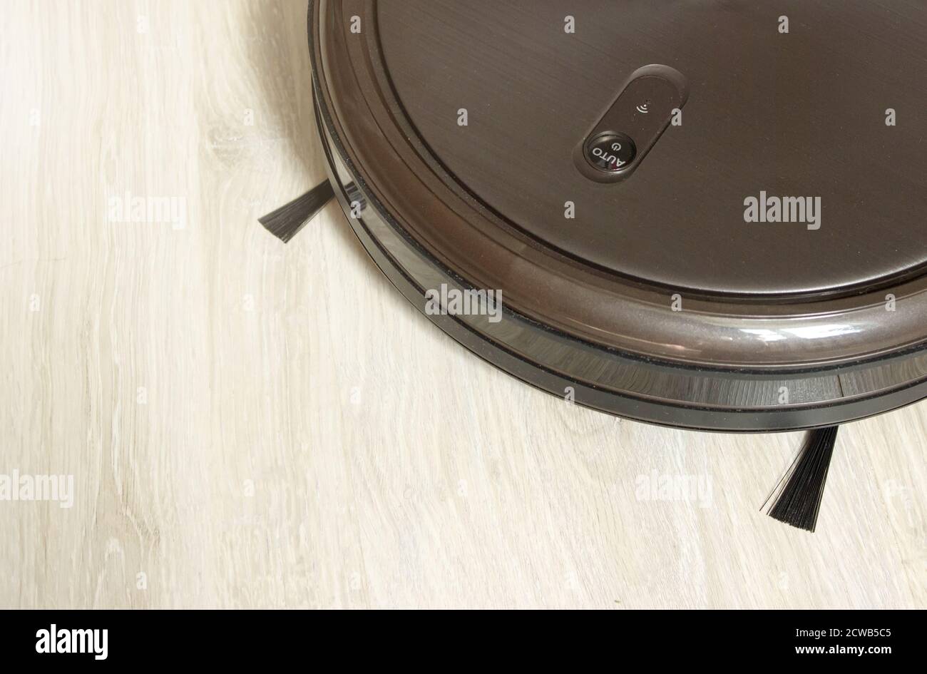 Robot vacuum cleaner performs automatic cleaning of the apartment at a certain time. Stock Photo