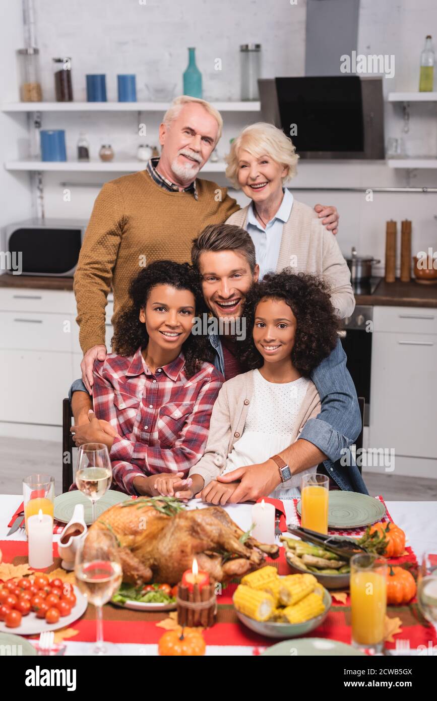 Selective focus of multicultural family embracing during thanksgiving celebration Stock Photo