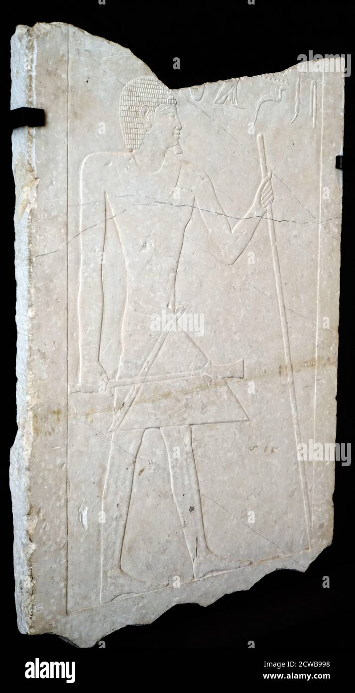 Relief depicting Senedjemib Mehi a vizier from the fifth dynasty of Egypt. Senedjemib Mehi started out his career under Djedkare Isesi and eventually became vizier under Unas. around 2300 BC. This relief of the Old Kingdom represents a man in the attitude of the march, holding in his left hand a stick and in the right a sceptre of command. He wears a loincloth with a smooth triangular tongue, held by a tied belt. It is adorned with a brace-let at each wrist as well as a wide necklace and a short and curled wig, which clears the goggle; a little beard ome his chin. Stock Photo