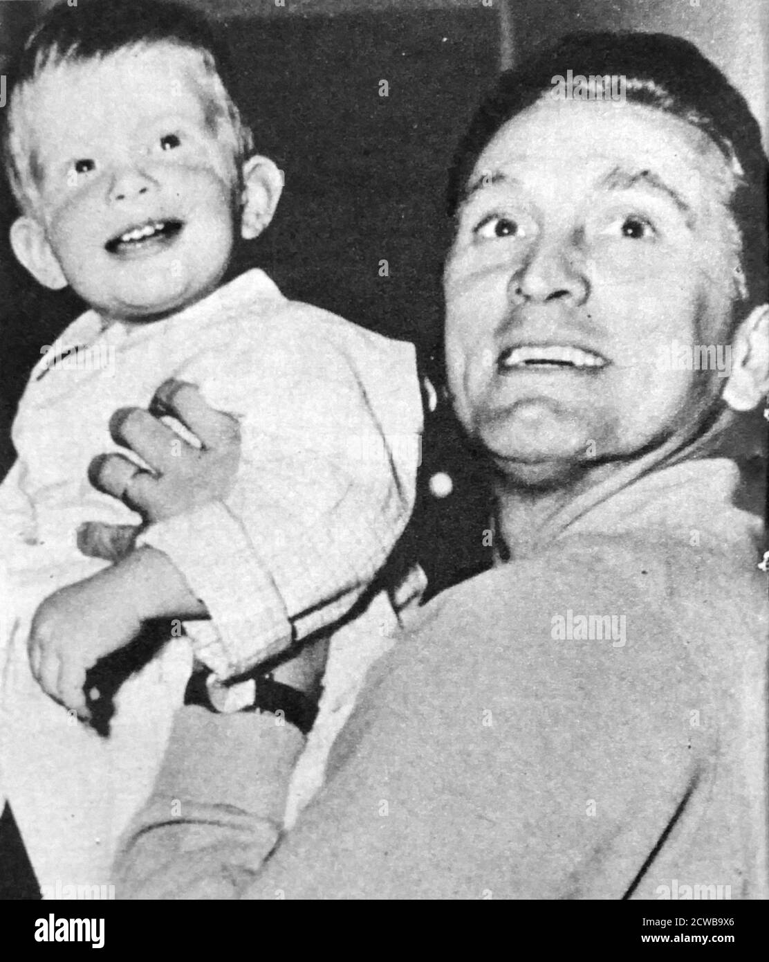 Kirk Douglas relaxing off-screen ith his son Peter. 1956. Kirk Douglas (born Issur Danielovitch Demsky; December 9, 1916 - February 5, 2020) was an American actor, producer, director, and author. Stock Photo