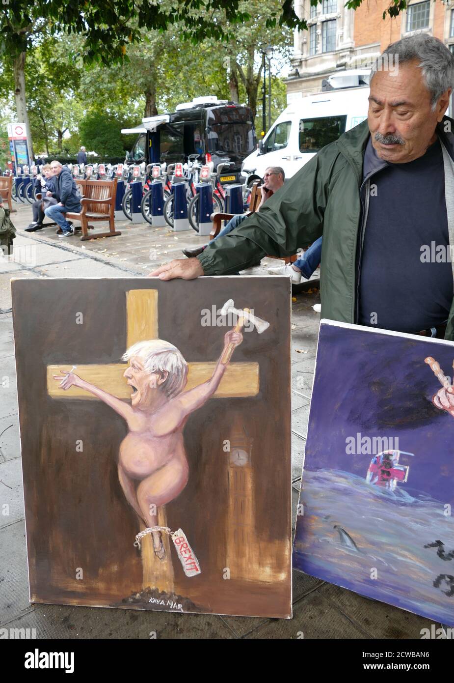 Satirical painting of Boris Johnson as a crucified victim of Brexit, painted by Kaya Ma (shown holding the work. September 2019 Stock Photo