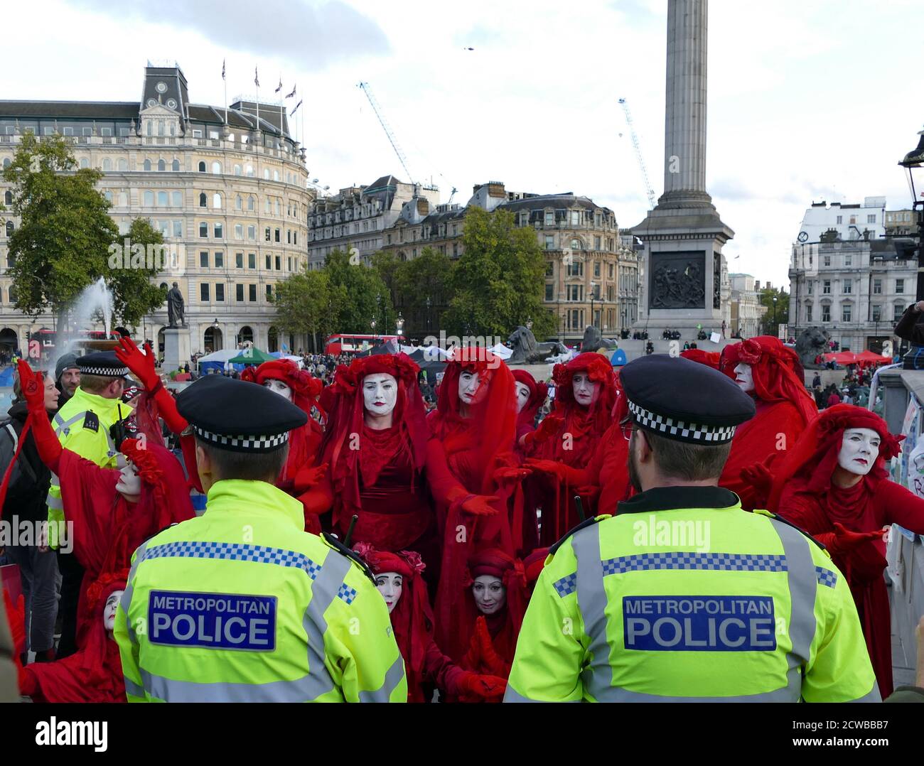 The Invisible Circus at the Extinction Rebellion protest 13th October 2019, at Trafalgar Square in central London . The Invisible Circus group from Bristol is made up of street performers dressed in red robes symbolizing the blood that binds humanity together. Stock Photo