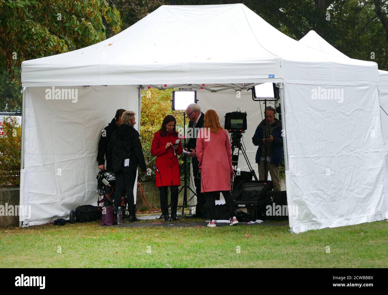 Tamara Cohen (red coat) a Sky News political correspondent prepares for interviews on College Green, Parliament, London. September 2019 Stock Photo