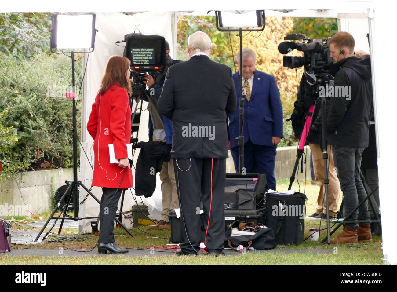 Tamara Cohen (red coat) a Sky News political correspondent prepares for interviews on College Green, Parliament, London. September 2019 Stock Photo