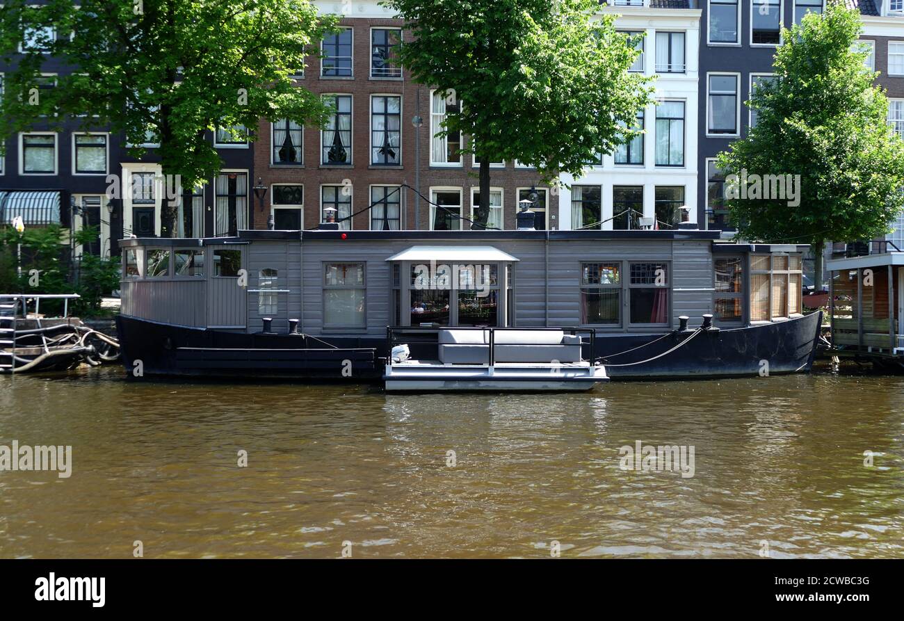 Canals in Amsterdam, Netherlands are used to transport people, tourists and supplies. Stock Photo