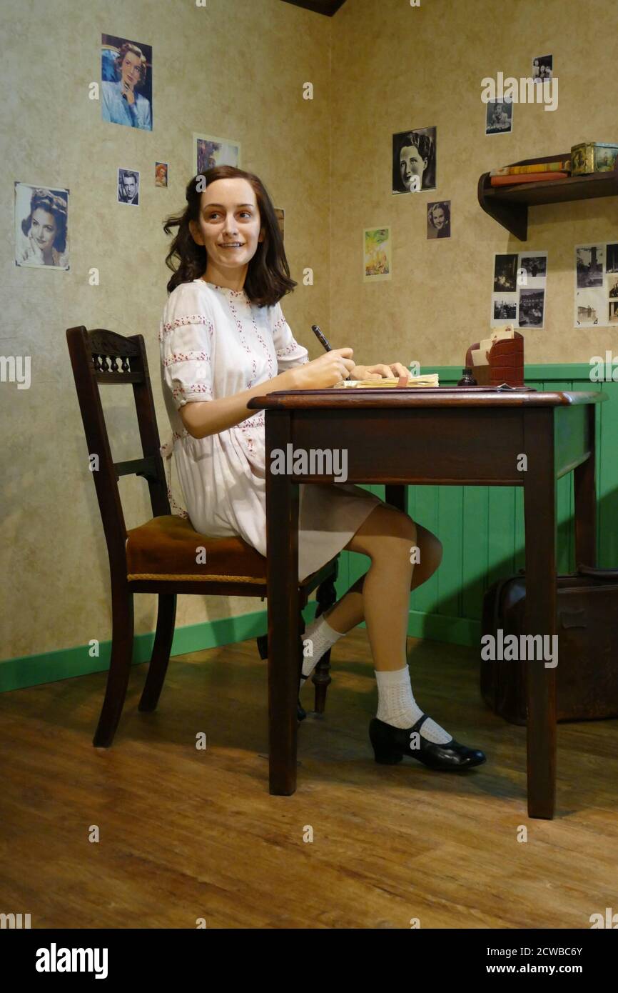 Waxwork recreation showing Anne Frank (1929 - 1945), in hiding in Amsterdam. Anne Frank was a German-born Dutch-Jewish diarist. One of the most discussed Jewish victims of the Holocaust, she gained fame posthumously with the publication of The Diary of a Young Girl, in which she documents her life in hiding from 1942 to 1944, during the German occupation of the Netherlands in World War II. Stock Photo