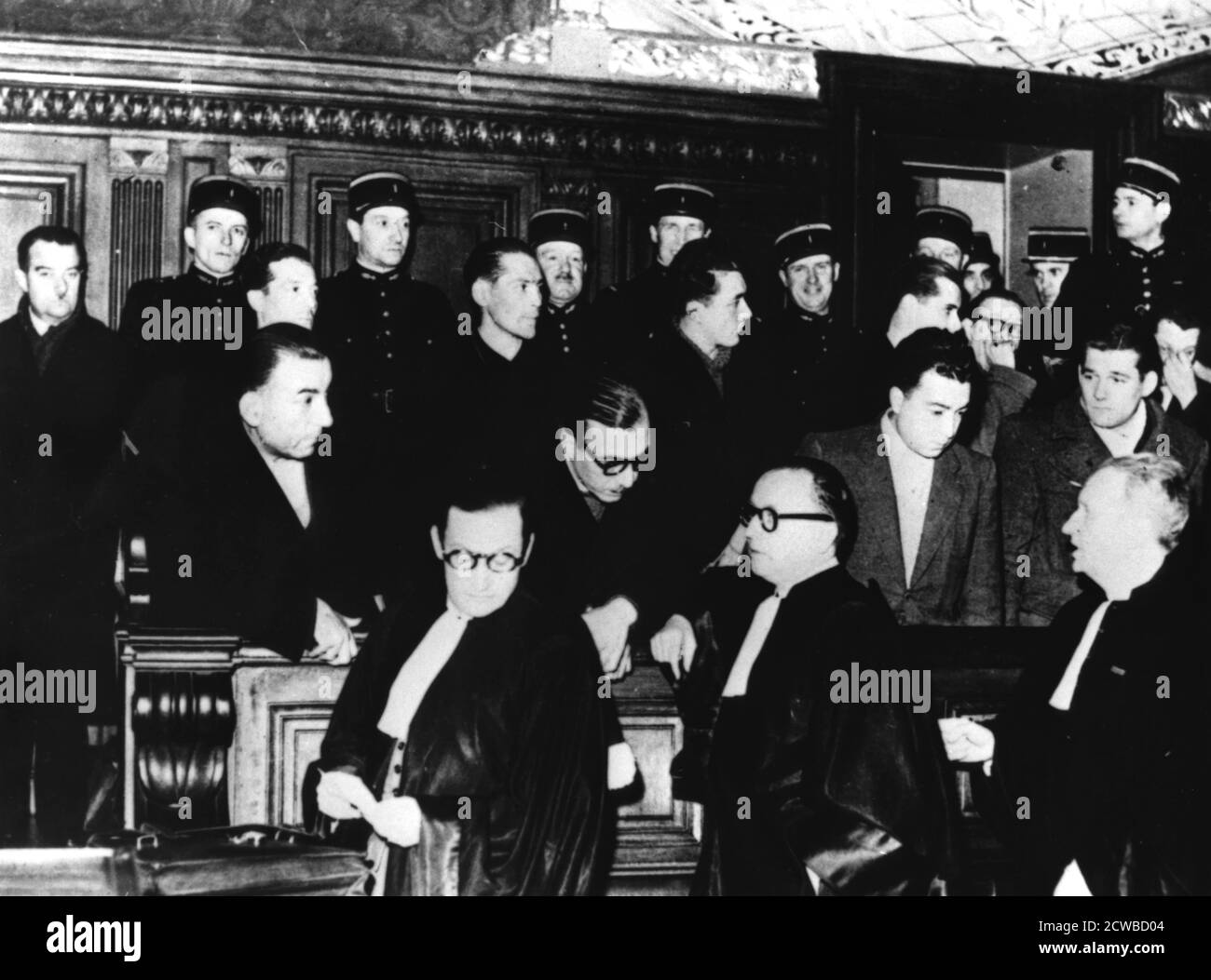Trial of French members of the Gestapo, Paris, 1-12 December 1944. The defendants, from left to right, are Henri Lafont, Pierre Bonny and Paul Clavie. They are defended by Messrs Floriot, Delaunay and Casanova. Bonny, a police inspector before the war, was apprehended on 18 September 1944 disguised as a tramp. The three were found guilty of collaboration and executed on 27 December. The photographer is unknown. Stock Photo