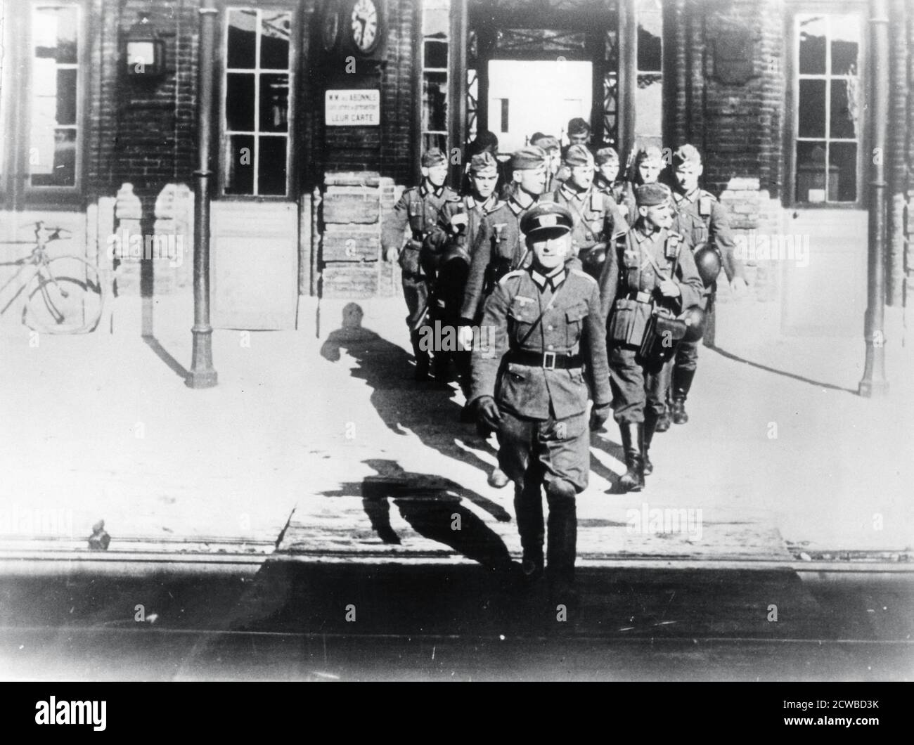 German army officer leading his company onto a railway station platform, Paris, August 1940. The photographer is unknown. Stock Photo