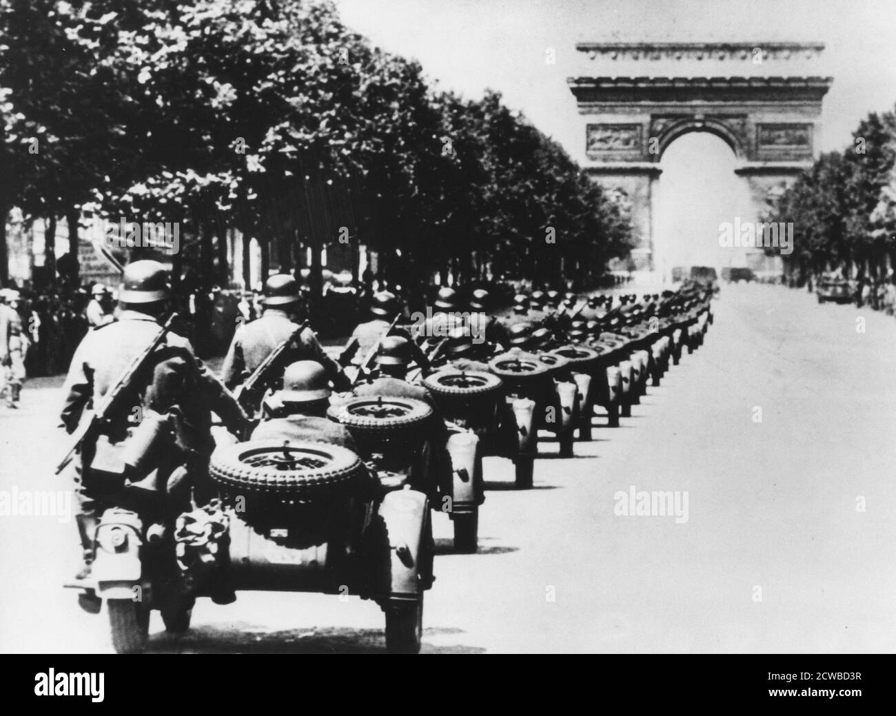 German soldiers on the Champs Elysees, Paris, 14 June 1940. A column of German troops in motorcycles with sidecars heading towards the Arc de Triomphe on the day that Paris fell to the Nazis. The photographer is unknown. Stock Photo