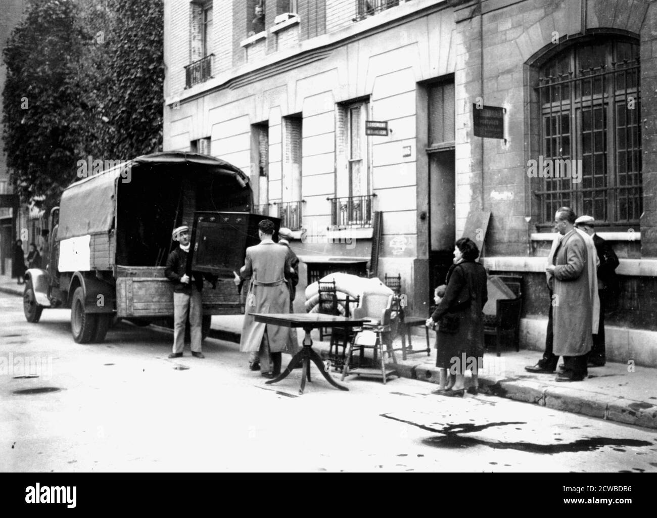 Delivery of furniture confiscated from Jews to victims of RAF bombing, Boulogne-Billancourt, Paris, April 1942. The photographer is unknown. Stock Photo