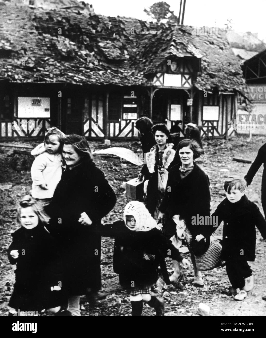 Families leaving their village bombarded during the Normandy landings, France, 1944. The photographer is unknown. Stock Photo