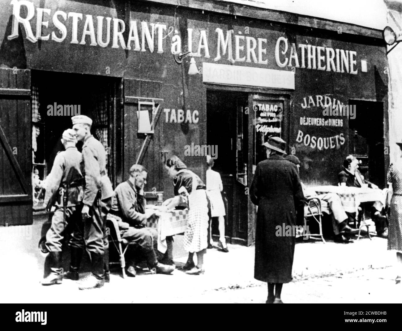 German soldiers at a restaurant, occupied Paris, June 1940. Paris fell to the Nazis on 14 June 1940, beginning a four year occupation. The photographer is unknown. Stock Photo