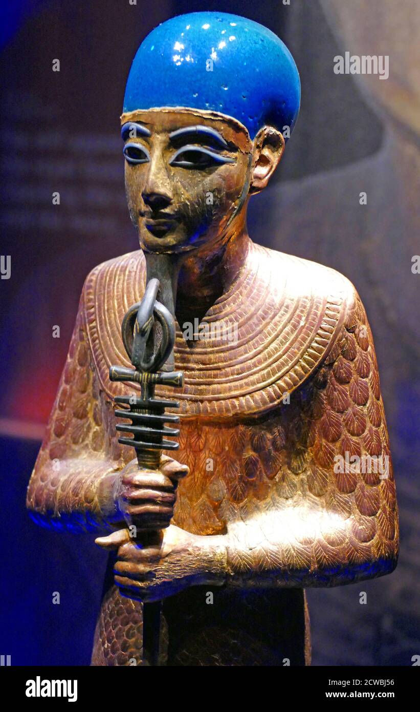 Gilded wooden statue of the God Ptah; wearing a cobalt blue glass cap. He carries a staff with the Ankh symbol and Djed pillar. Tomb of King Tutankhamun. 1326 BC Stock Photo