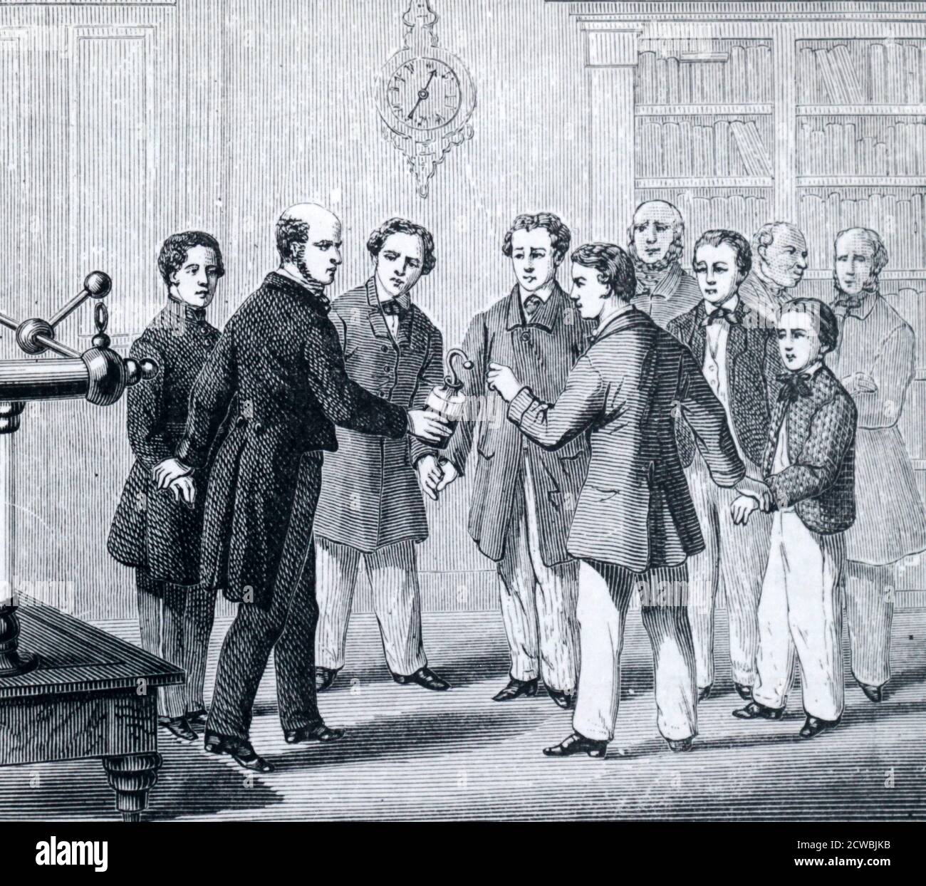 Engraving depicting the process of sending an electric shock through a circle of people. One person holds a charged Leyden jar by the outside coating and the person next to him touches the knob, sending a shock through the whole circle. Stock Photo