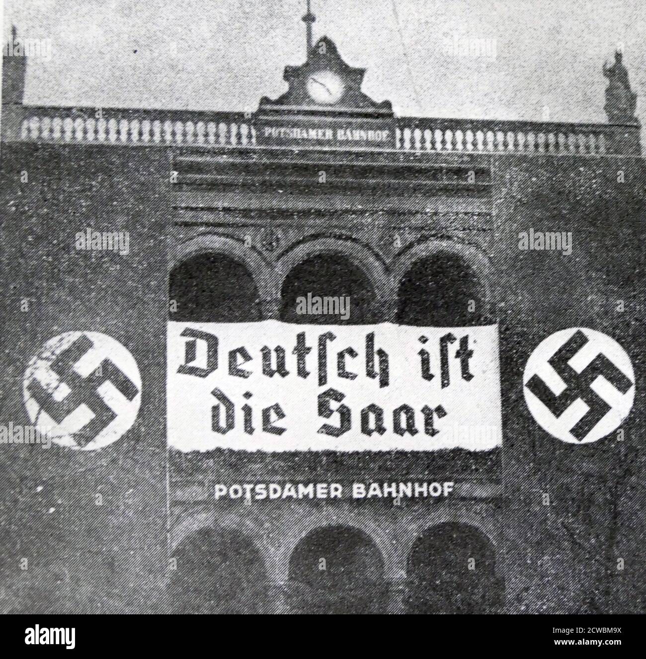 Black and white photo of the aftermath of the Saar Plebiscite, 13 January 1935; a sign with Nazi symbols celebrating the annexation of Saar. Stock Photo