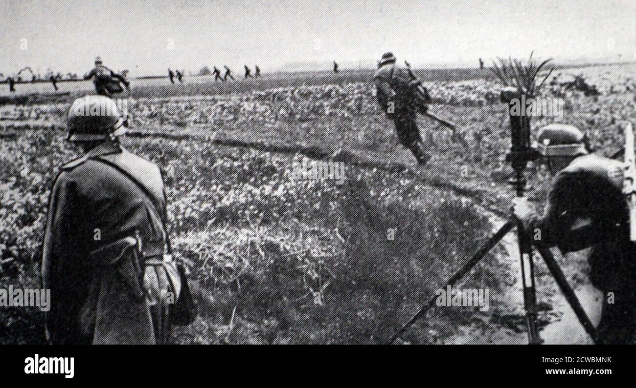 Black and white photograph of the front during the winter of 1939-1940; German troops patrol a field. Stock Photo