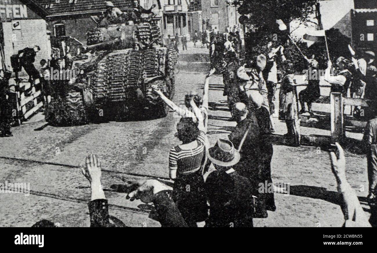 Black and white photograph of World War II (1939-1945) showing images a free Europe after the defeat of Nazi Germany; a British tank drives through the streets of the Dutch city of Ede. Stock Photo