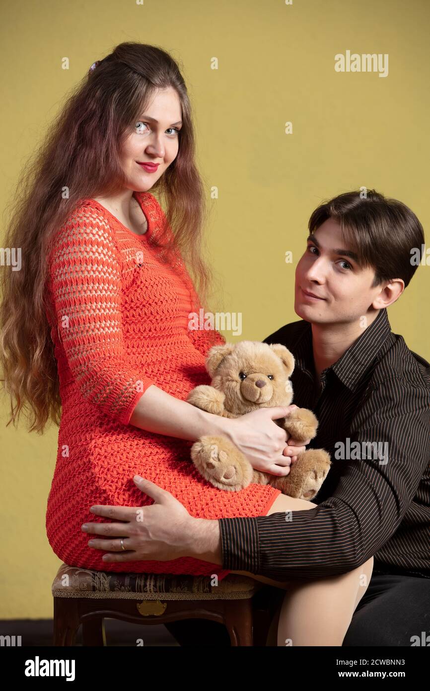 A handsome man hugs a beautiful pregnant wife and a teddy bear Stock ...