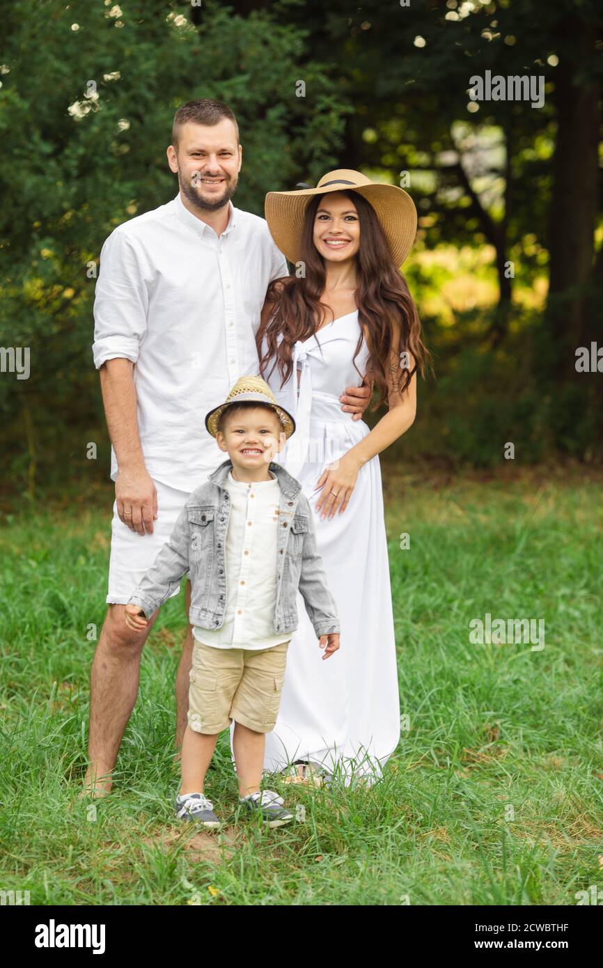 Beautiful mum, dad and their cute little child have fun together and ...