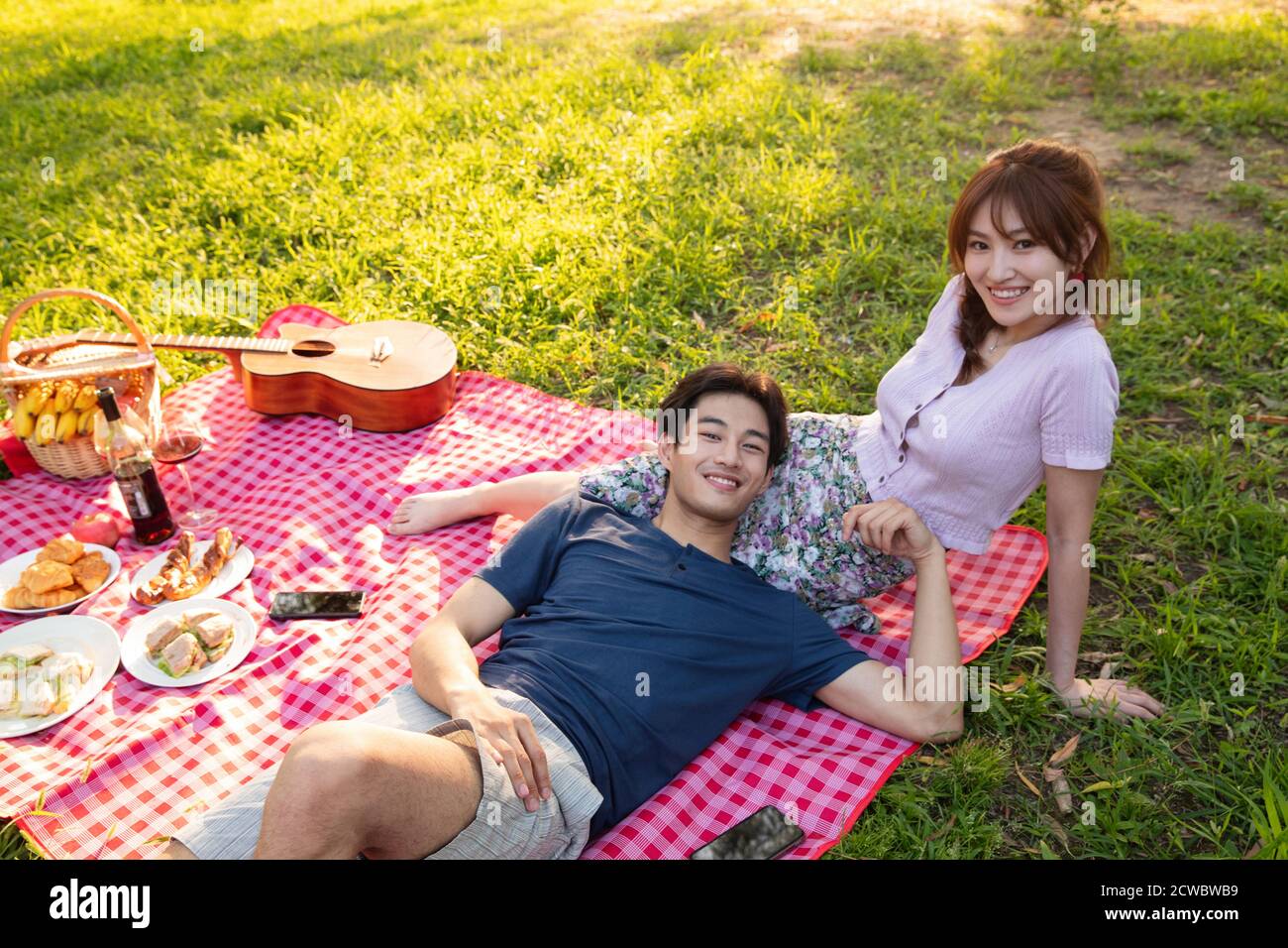 Happy couple lying on the grass Stock Photo - Alamy
