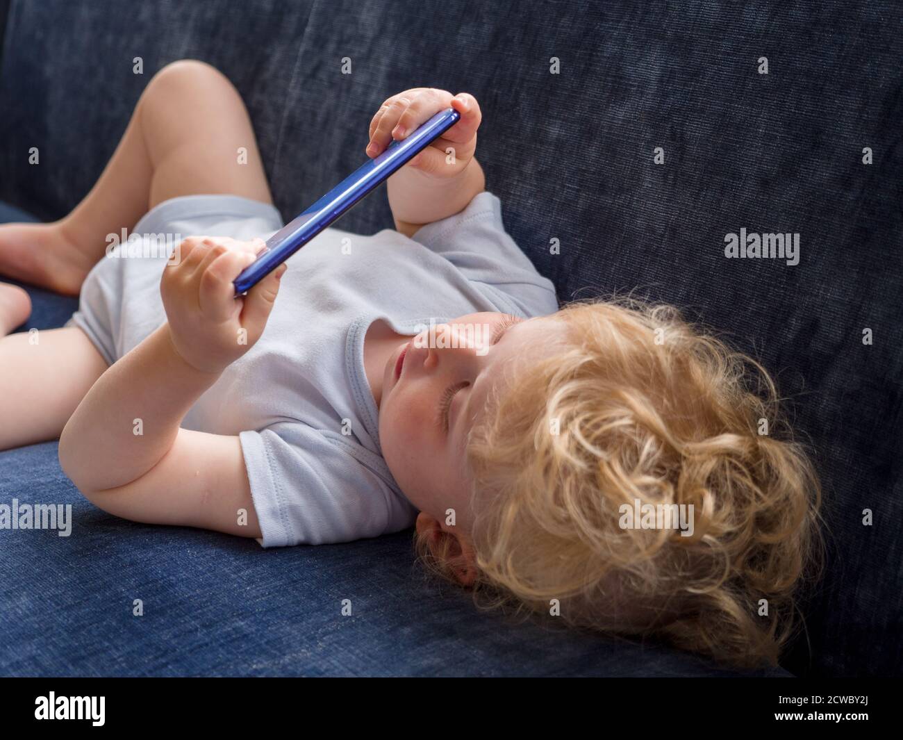 One year old baby watching youtube video on a mobile phone Stock Photo