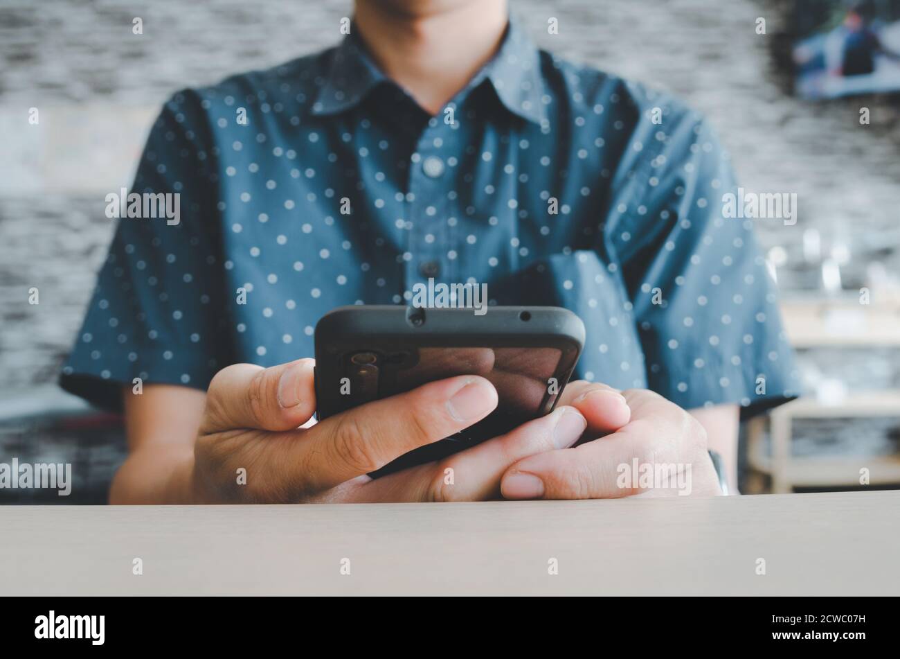 man using mobile smart phone in coffee shop. Stock Photo
