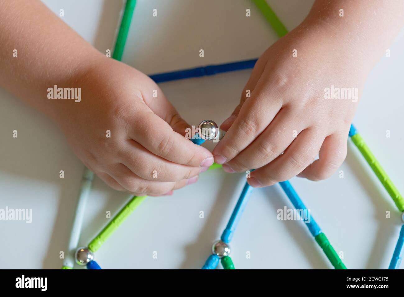 Hand Holding Magnet Toy Bars and Magnetic Balls Stock Photo