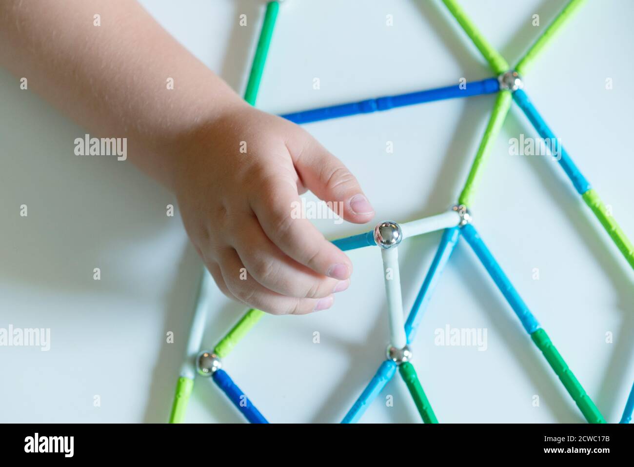 Hand Holding Magnet Toy Bars and Magnetic Balls Stock Photo