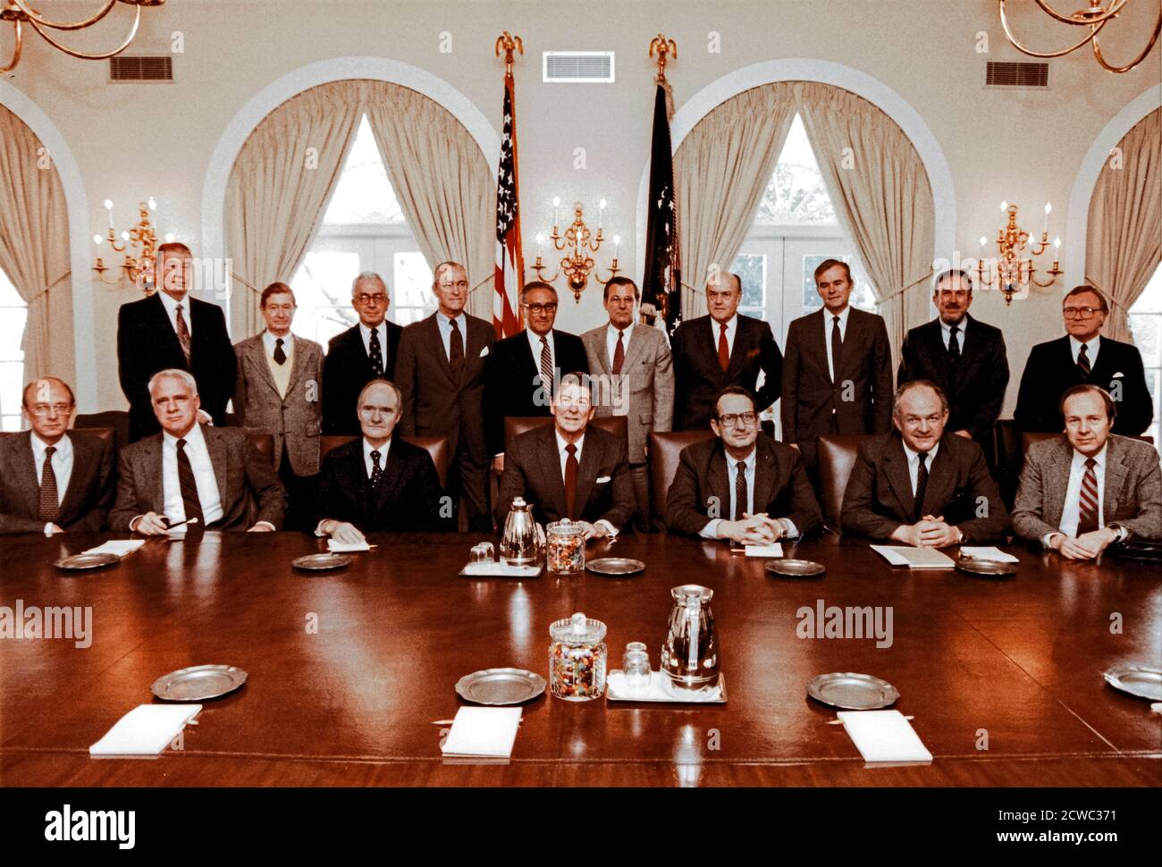 In this photo released by the White House, United States President Ronald Reagan poses with the President’s Commission on Strategic Forces and the Special Counselors to the commission in in the Cabinet Room of the White House in Washington, DC on February 9, 1983.  Seated in the front row: James Woolsey; Dr. James Schlesinger; Brent Scowcroft, Chairman; President Reagan; Dr. John Deutsch; Thomas Reed; Dr. William Perry.  Standing in the back row, from left to right are: John Lyons; Vice Admiral Levering Smith, US Navy (Retired); Lloyd Cutler; Richard Helms; Dr. Henry Kissinger; Donald Rumsfeld Stock Photo
