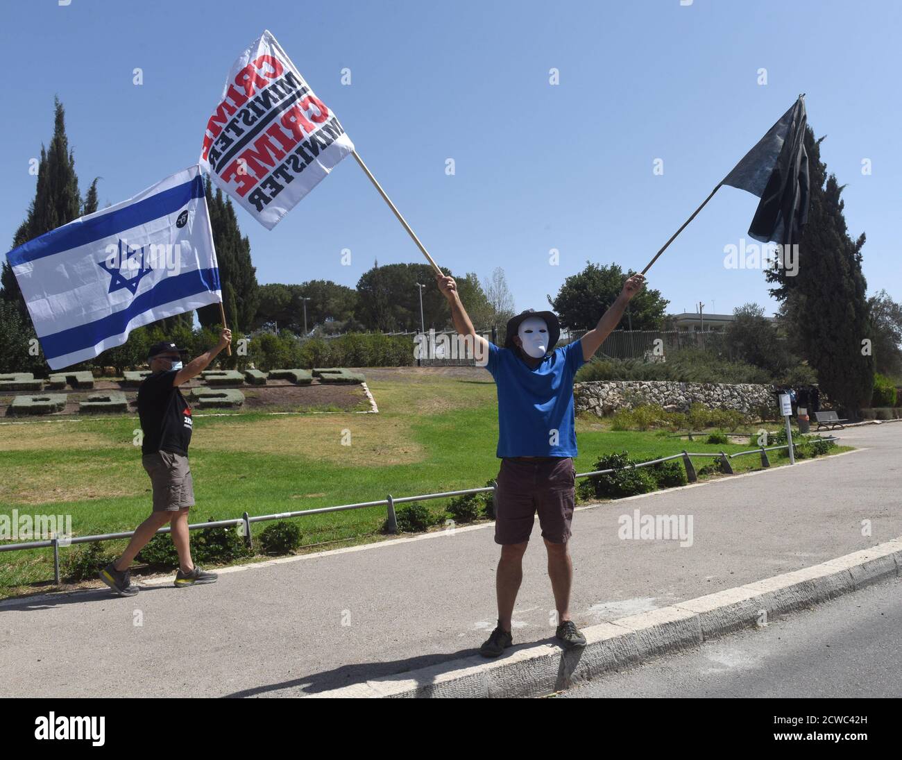 Jerusalem, Israel. 29th Sep, 2020. An Israeli holds a black flag and another reading CRIME MINISTER at a protest during a nationwide COVID-19 lockdown, against Prime Minister Benjamin Netanyahu's proposed bill to restrict protests, outside the Knesset, the Parliament, on Tuesday in Jerusalem, September 29, 2020. The bill would forbid demonstrators from traveling more than one kilometer, 0.621 mile, from their homes, therefore stopping the weekly anti-Netanyahu protests outside his residence in Jerusalem. Photo by Debbie Hill/UPI Credit: UPI/Alamy Live News Stock Photo