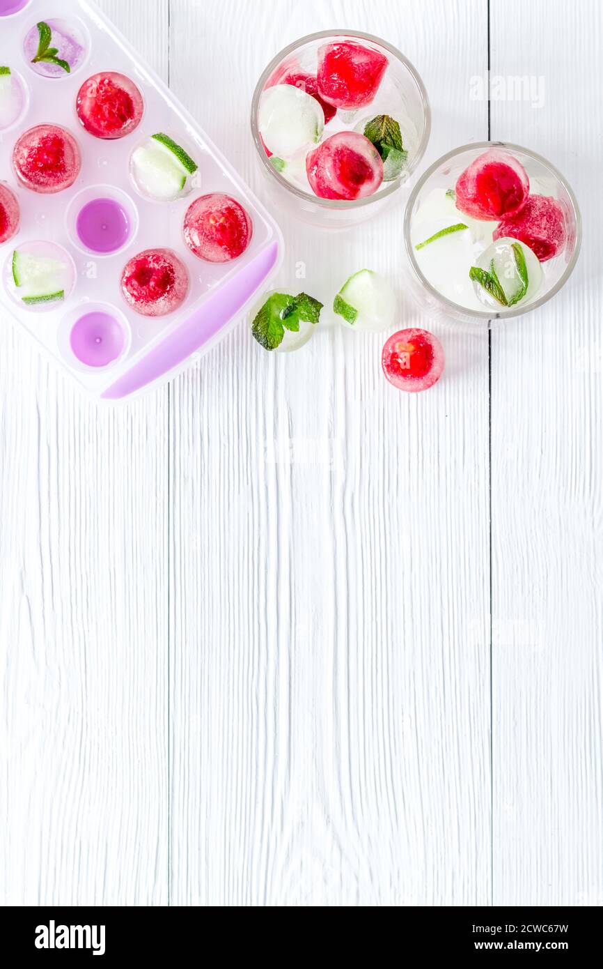 Raspberry and lime in ice cubes on white table top view copy space ...