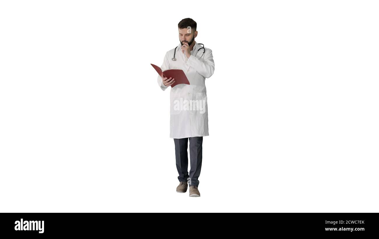 Doctor reading a book or a journal while walking on white backgr Stock Photo