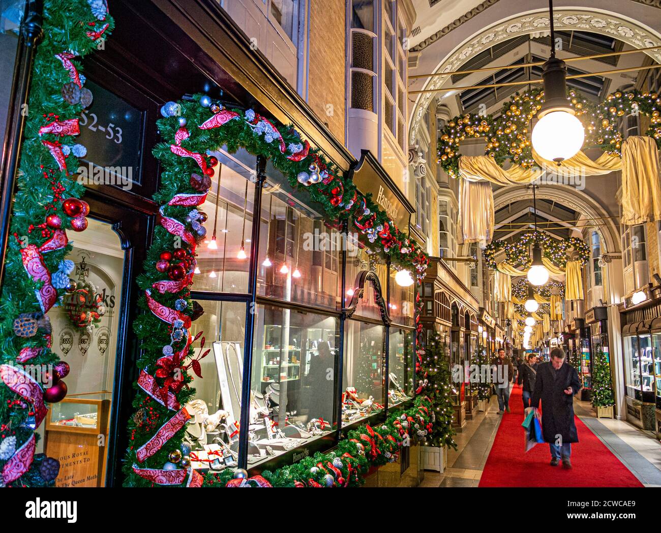 LONDON CHRISTMAS Burlington shopping arcade in Piccadilly with traditional Christmas festive decorations and Christmas shoppers shopping in covered luxury retail interior environment London UK Stock Photo
