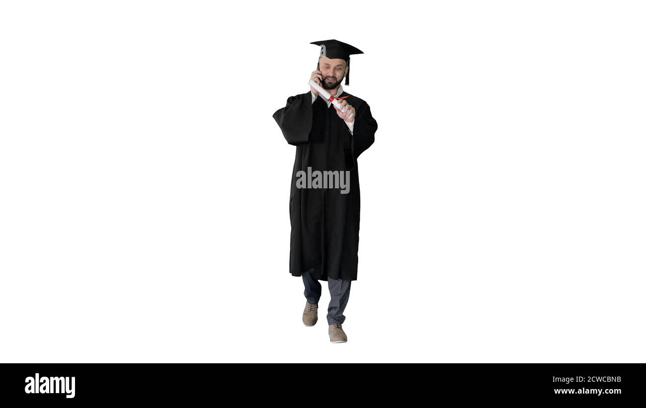 Graduating student walking and making a call on white background Stock Photo