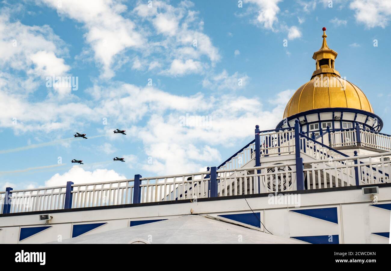 Airbourne Airshow and Eastbourne Pier, England. Vintage fighter planes passing over the dome of Eastbourne Pier during the annual aerobatics air show. Stock Photo