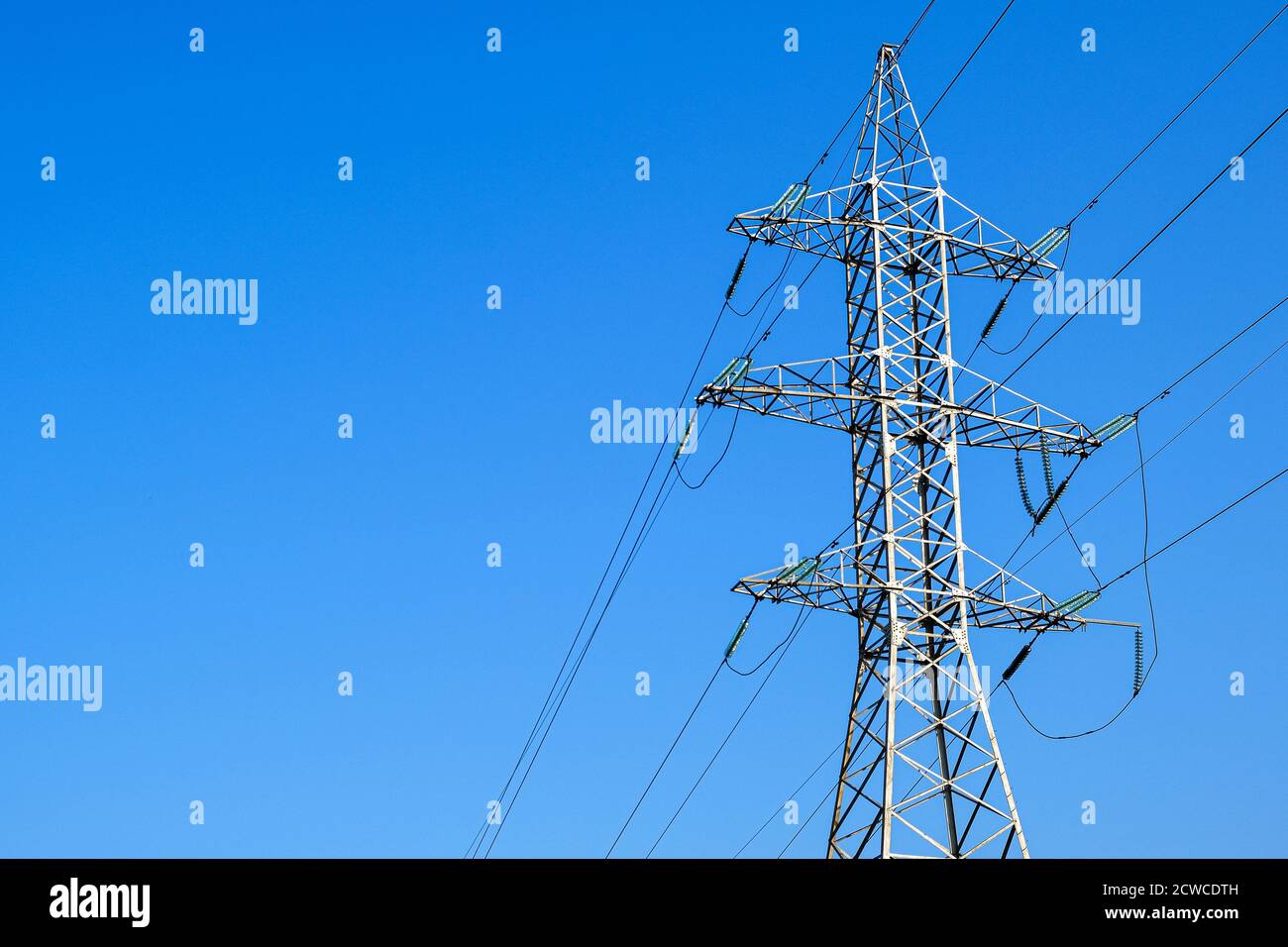 Towers with insulators on which the wires are fixed. High-voltage power transmission line. An extended structure of wires, cables and supports for the Stock Photo