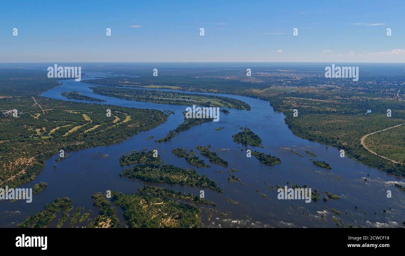 Aerial panorama view of Zambesi River delta ahead of Victoria Falls, bush land and village Livingstone in the background. Stock Photo