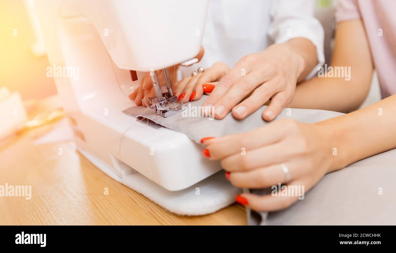 Student girl with teacher in dressmaking class, woman sewing lessons Stock Photo