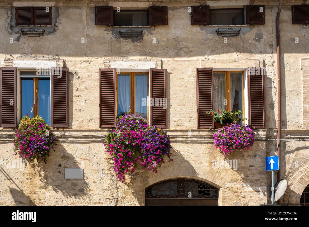 Vintage windows with open wooden shutters and fresh flowers Stock Photo