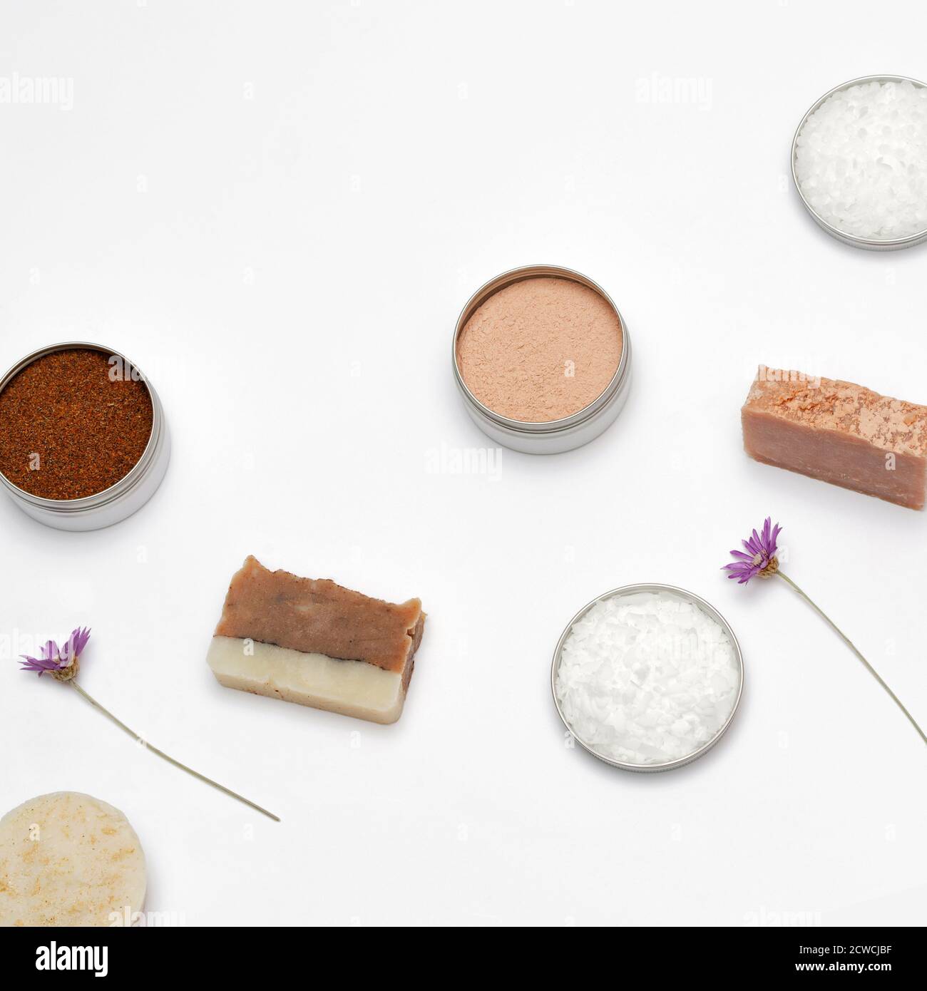 Ingredients for the production of cosmetics on a white background. Clays, wax, herbal powders, dried flowers, raspberry ketone. Natural cosmetics concept. Stock Photo