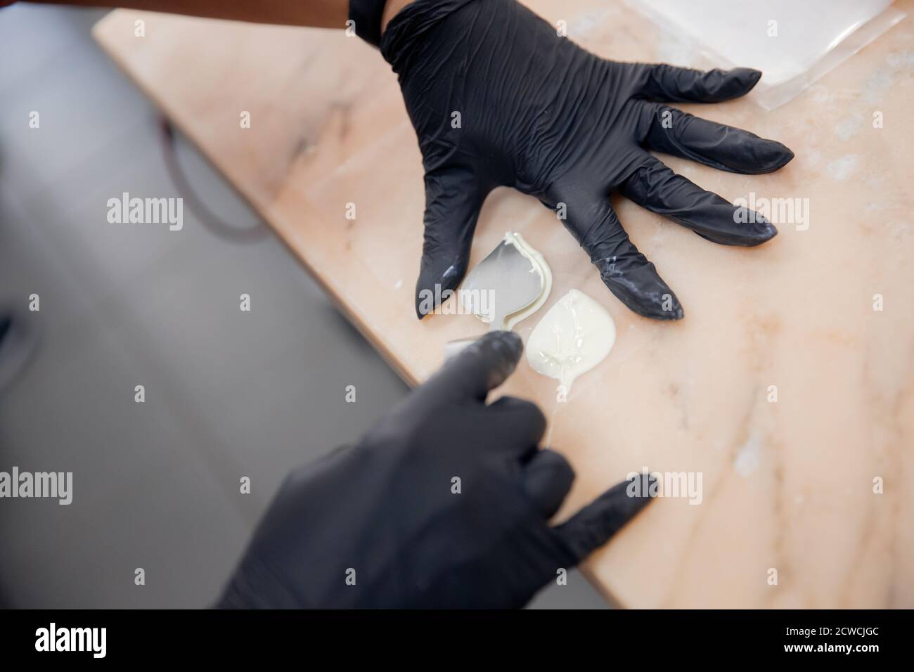 Chef hand in patisserie restaurant prepares cakes and decorates with chocolate icing Stock Photo