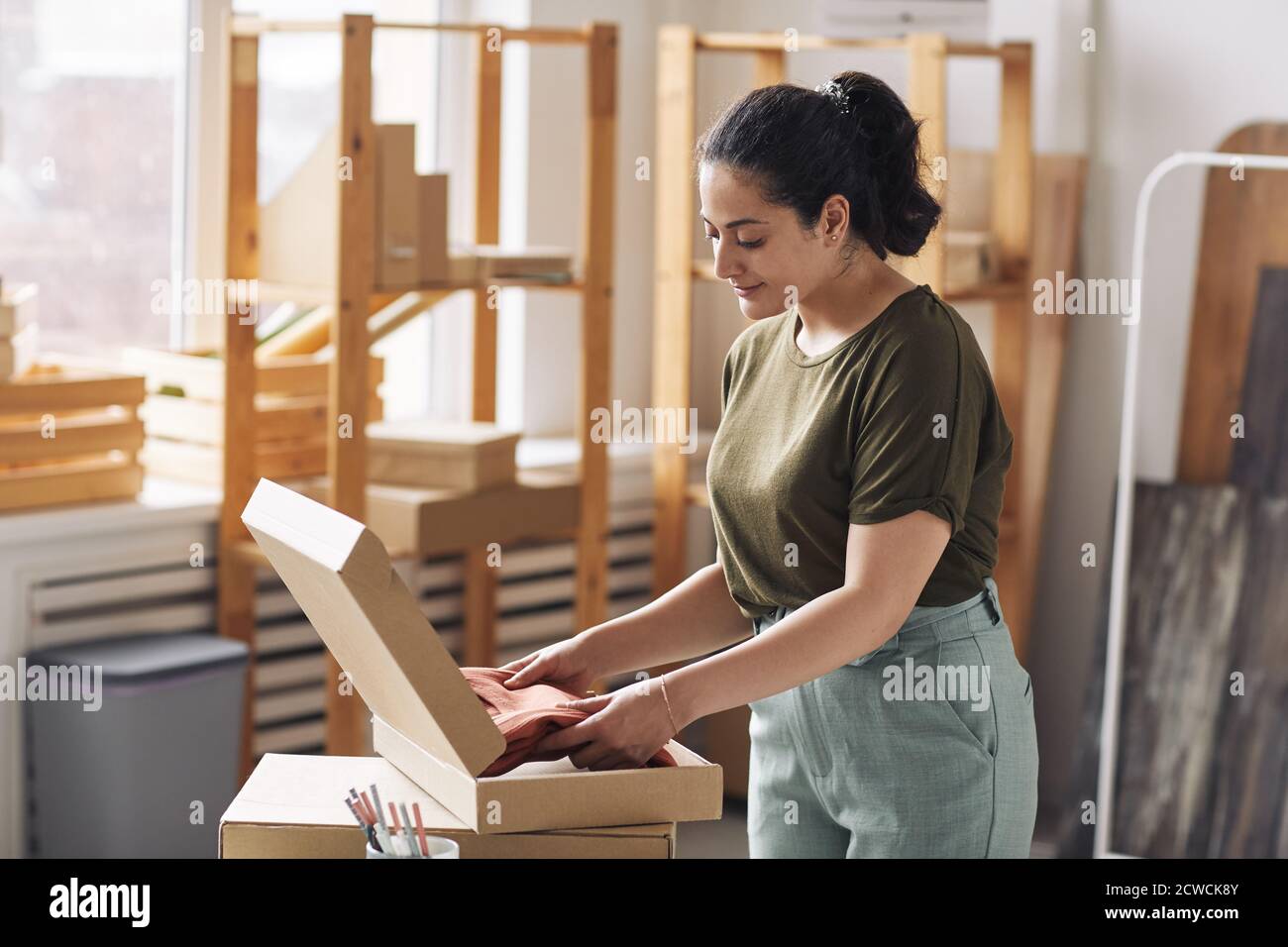 Девушки заворачивают. Упаковывают девушку. Упакованная девушка. Девушка собирает коробки. Женщина на упаковке.