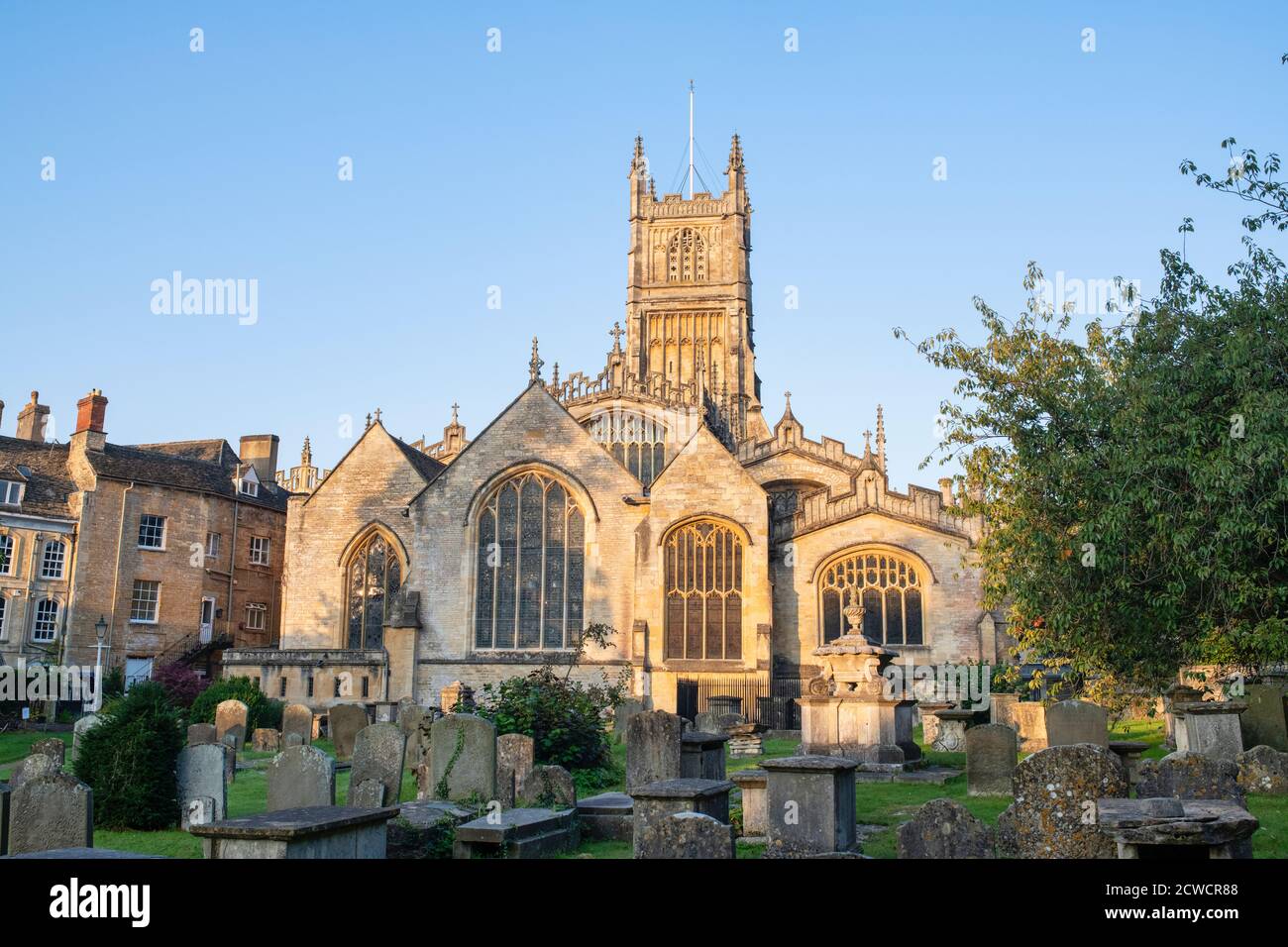 The Church of St. John the Baptist from the garden of rememberance at sunrise in autumn. Cirencester, Cotswolds, Gloucestershire, England Stock Photo