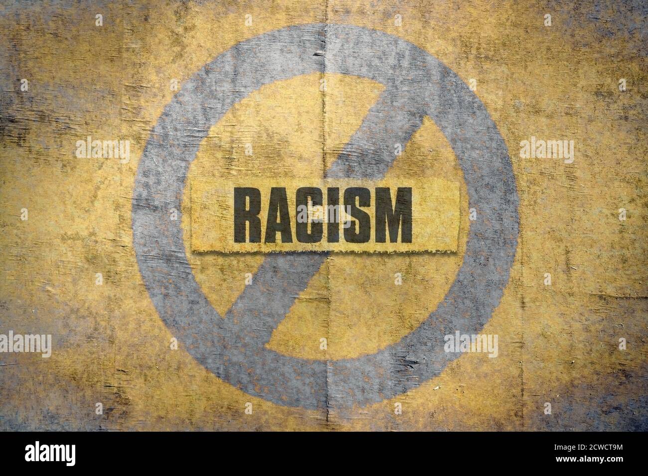 Word Racism written on a grunge yellow background Stock Photo