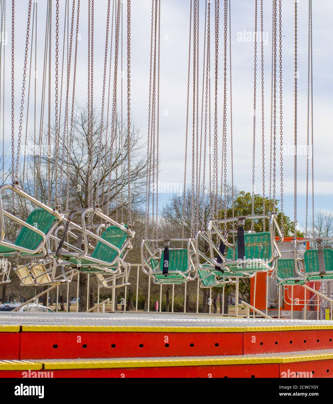 Colorful giant carnival ride swings sit empty. Stock Photo