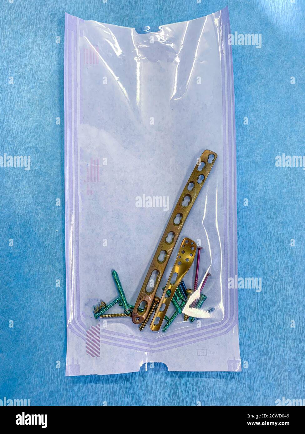 explanted titanium screws and titanium plates in different colors and