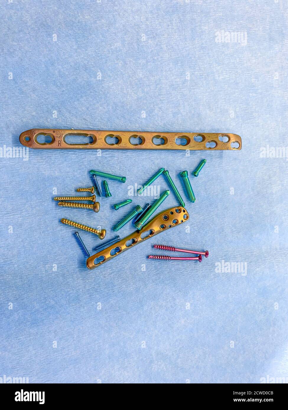 explanted titanium screws and titanium plates in different colors and