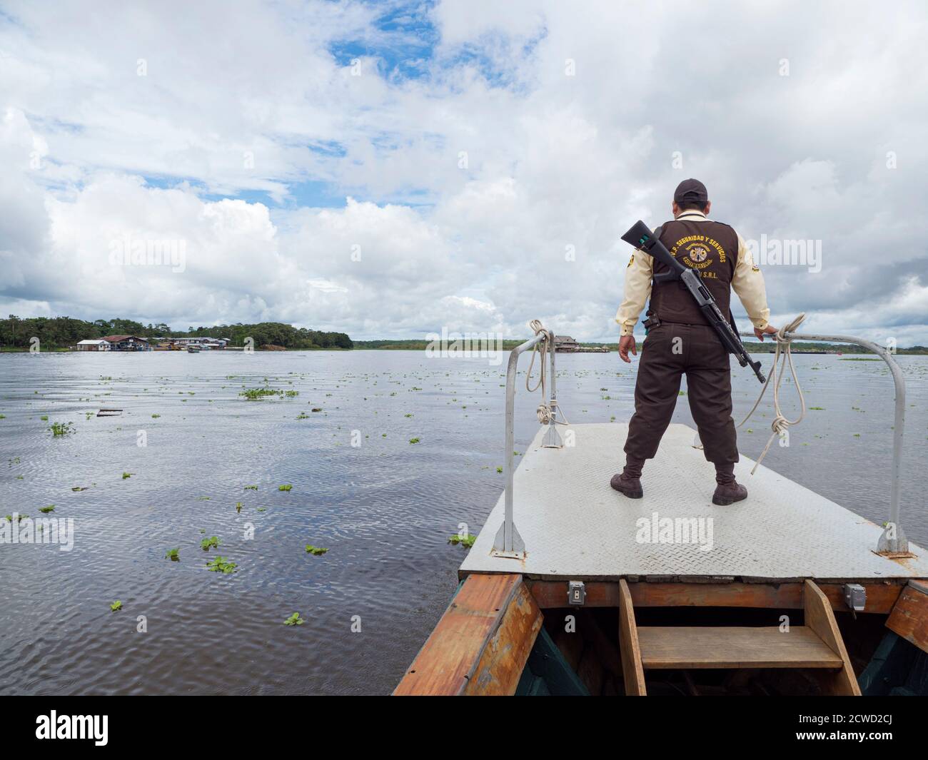 Armed guard escorts tourists to lunch on the Amazon River near Iquitos, Peru. Stock Photo